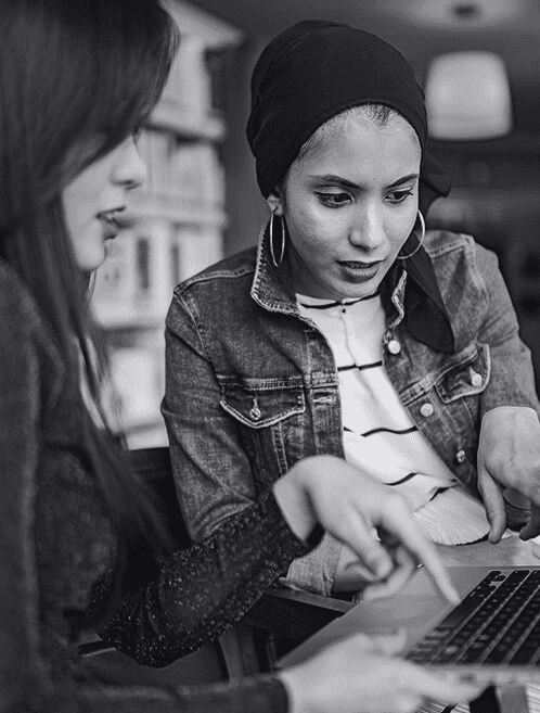 Zwei Frauen arbeiten vor einem Laptop